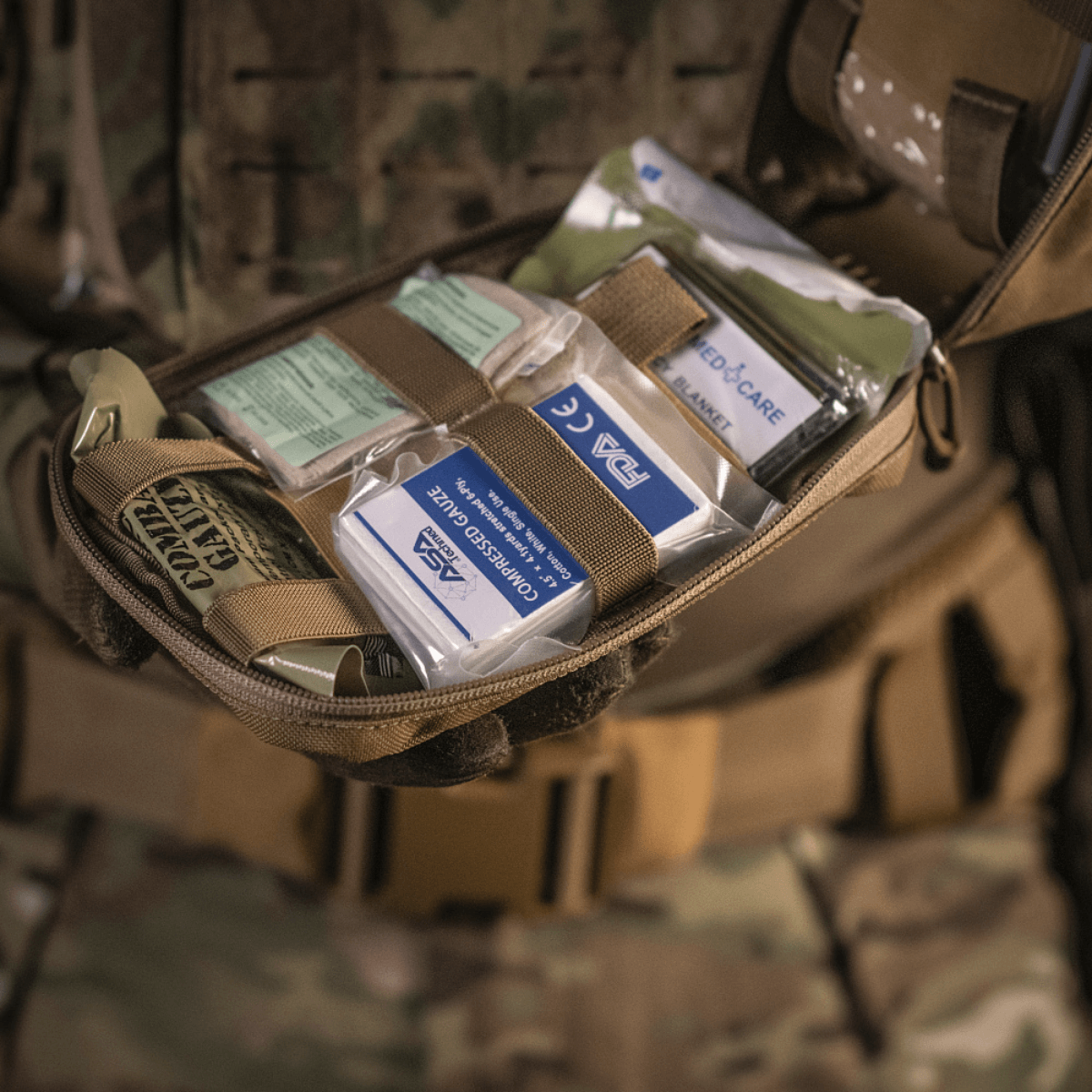 M-Tac Medical Pouch Rip Off kiinnitetty MOLLE Velcro -paneeleihin ensiapupakkauksen kanssa.