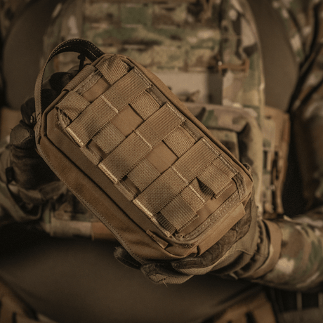 Taktinen käyttö M-Tac Medical Pouch Rip Offista kiinnitettynä MOLLE Velcro -paneeleihin, sopii nopeaan pääsyyn ensiapupakkaukseen.