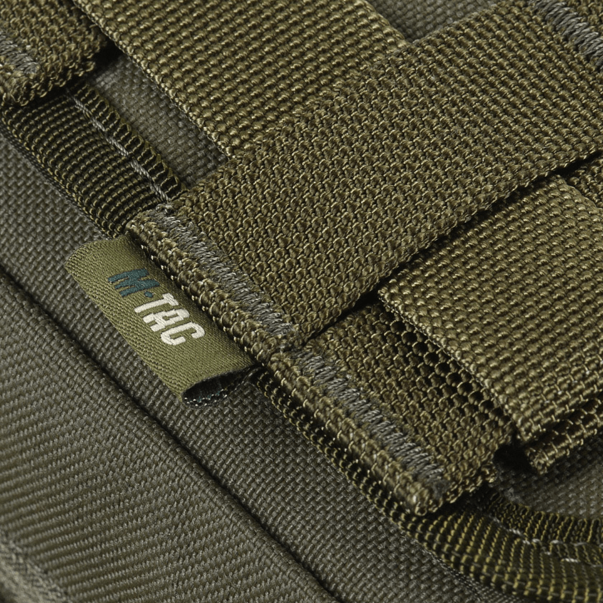Lähikuva M-Tac Medical Pouch Rip Offista kiinnitettynä MOLLE Velcro -paneeliin, näyttää laukun kestävän materiaalin.