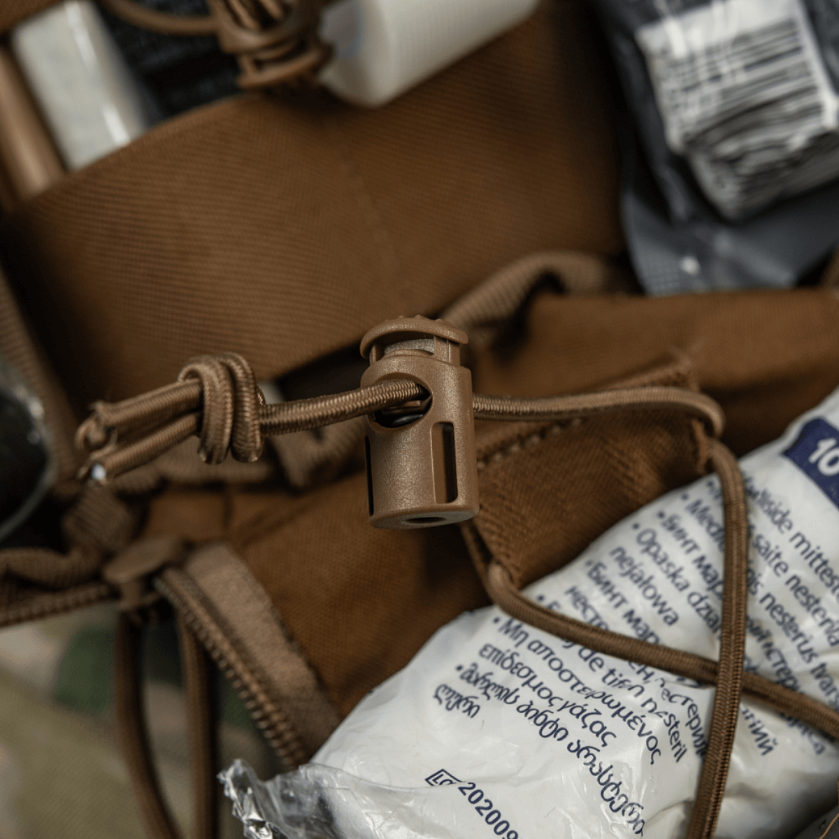 Lähikuva M-Tac Medical Pouch Elite Rip Off -taktisen laukun sisällöstä, joustavat hihnat ja yksityiskohtainen järjestely
