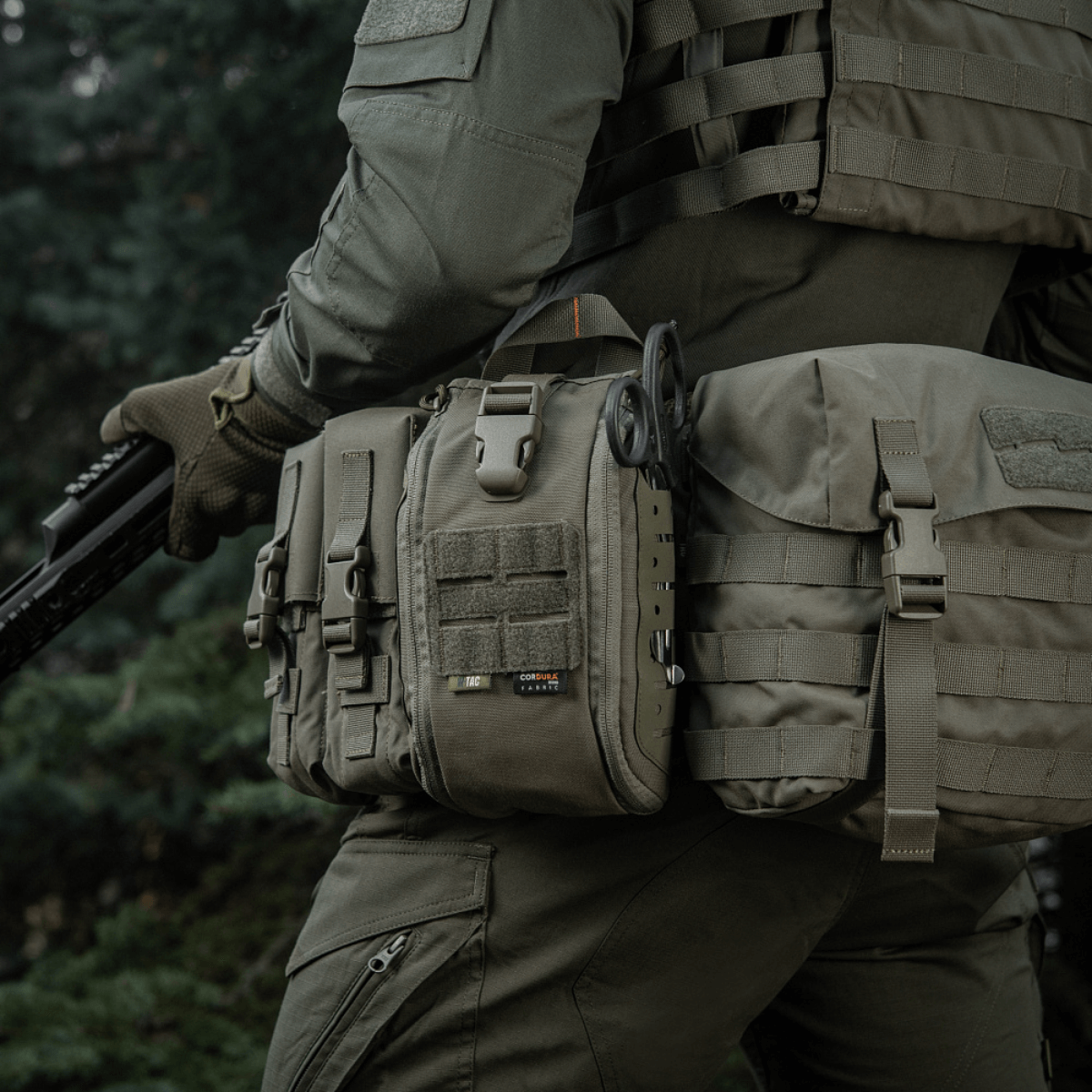 M-Tac Medical Pouch Elite Rip Off kiinnitetty taktiseen varustukseen luonnossa, helposti saatavilla ja valmiina kriittisiin ensiaputilanteisiin