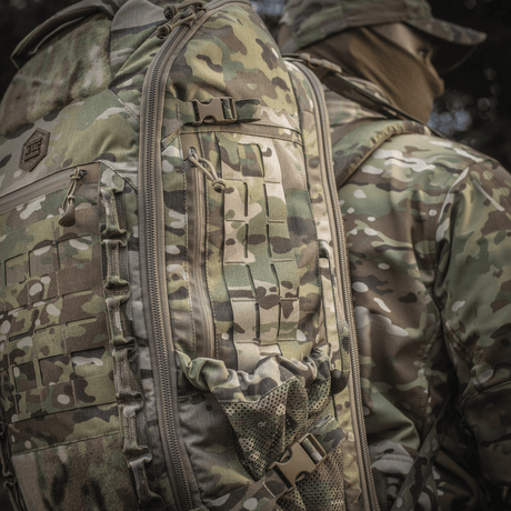 M-Tac Rygsæk Large Gen.III Elite käytössä, camouflaged taktinen reppu ergonomisella muotoilulla, valmistettu kestävästä Cordura-materiaalista.