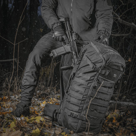 M-Tac Rygsæk Gen.II Elite Large, henkilö metsässä asekuljetukseen, kestävä Cordura-materiaali ja ergonominen muotoilu.
