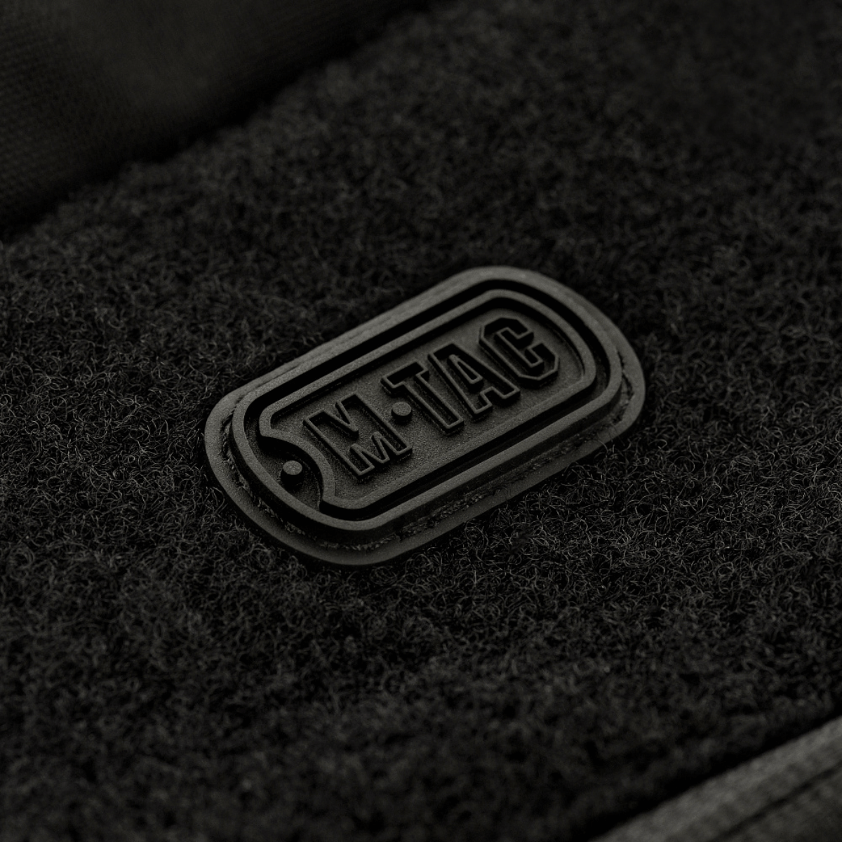 M-Tac Rygsæk Gen.II Elite Large, musta logo keskipisteessä, valmistettu kestävästä Cordura-kankaasta kestävyyttä ja toimivuutta varten.