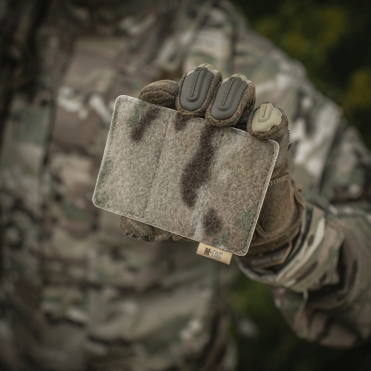 M-Tac paneeli patcheille MOLLE 120x85 camo-yksityiskohdalla, pidetään taktisia varusteita käyttävän henkilön kädessä, hook & loop overflade