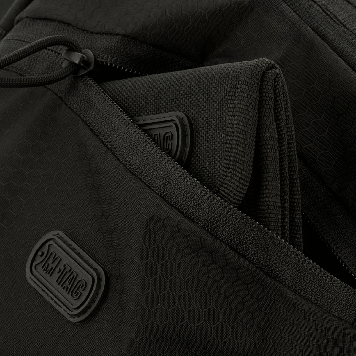 Lähikuva M-Tac Sphaera Hex Hardsling Bag vetoketjukompartmenteilla ja M-Tac-merkinnällä, valmistettu kestävästä Cordura/Hex-polyesteristä.