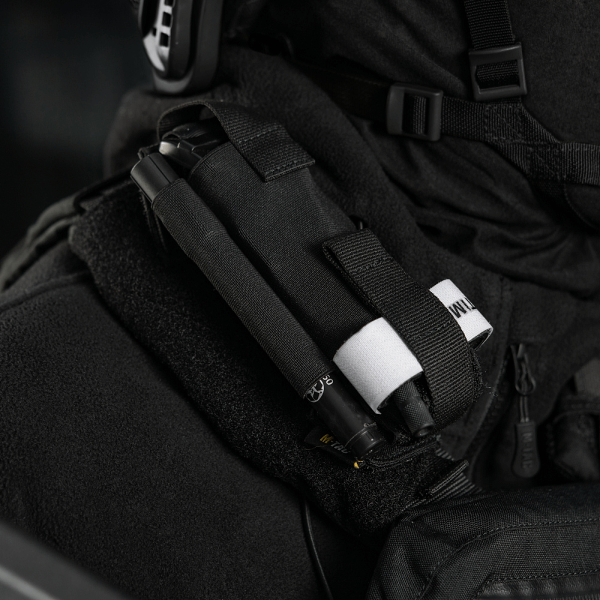 M-Tac Elastisk Tourniquet Pouch Molle Gen.III kiinnitettynä univormuun, näyttää joustavan pidikkeen ja nopean pääsyjärjestelmän.