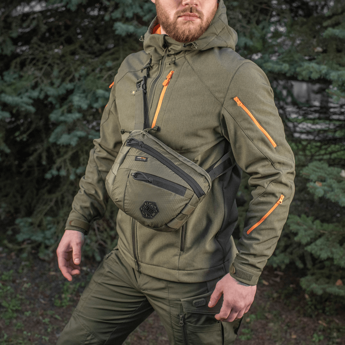 M-Tac Sphaera Hex Hardsling Gen.II Elite miehellä sotilasvihreissä vaatteissa luonnossa.