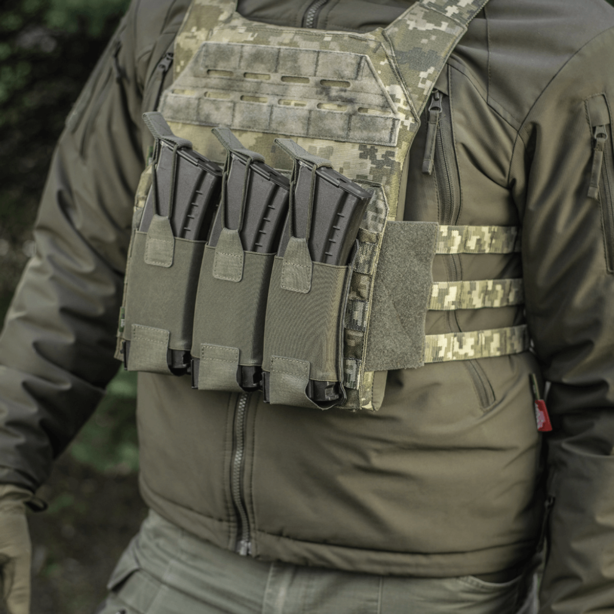 M-Tac Elastinen Triple Magazine Pouch Elite kiinnitettynä kolmella AK/AR-lippaalla taktiseen liiveen kenttäympäristössä.