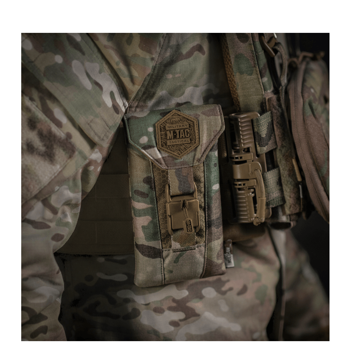 M-Tac Smartphone Lomme Elite Large Hex CORDURA HEX -materiaalista, näytetty kiinnitettynä taktisiin varusteisiin maastotaustalla.