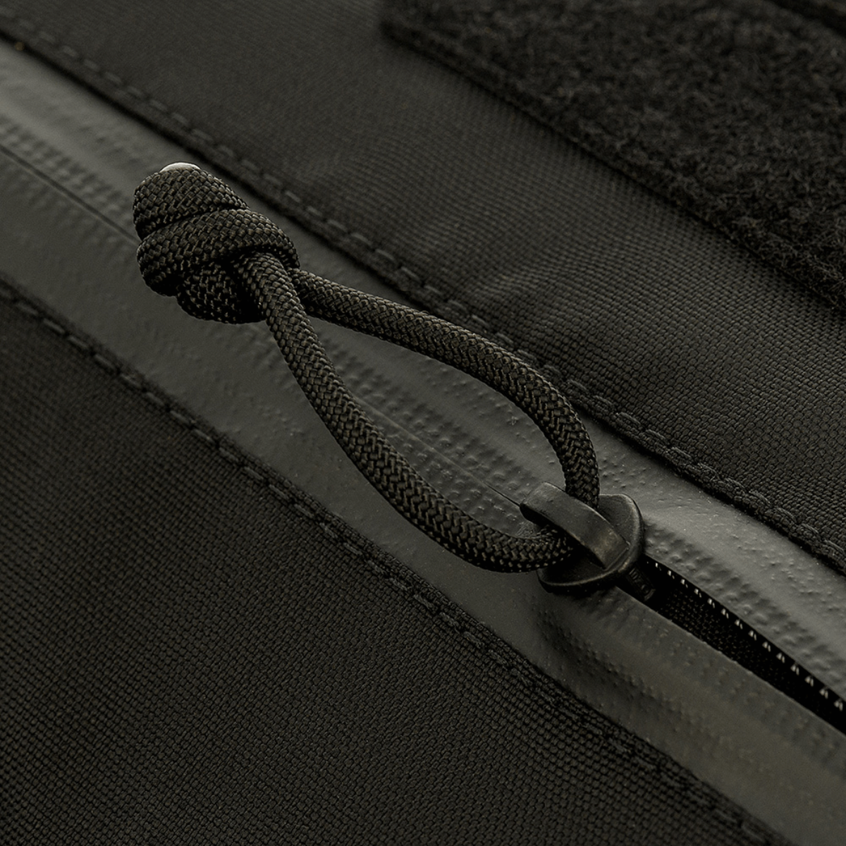 Lähikuva M-Tac taktinen käsilämmitin Elite, kestävä Cordura 500D -kangas ja vetoketjun yksityiskohta.