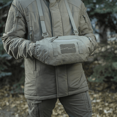 Henkilö käyttää M-Tac Taktisk Håndvarmer Eliteä, valmistettu kestävästä Cordura 500D:stä pehmeällä fleecevuorella, ulkoympäristössä