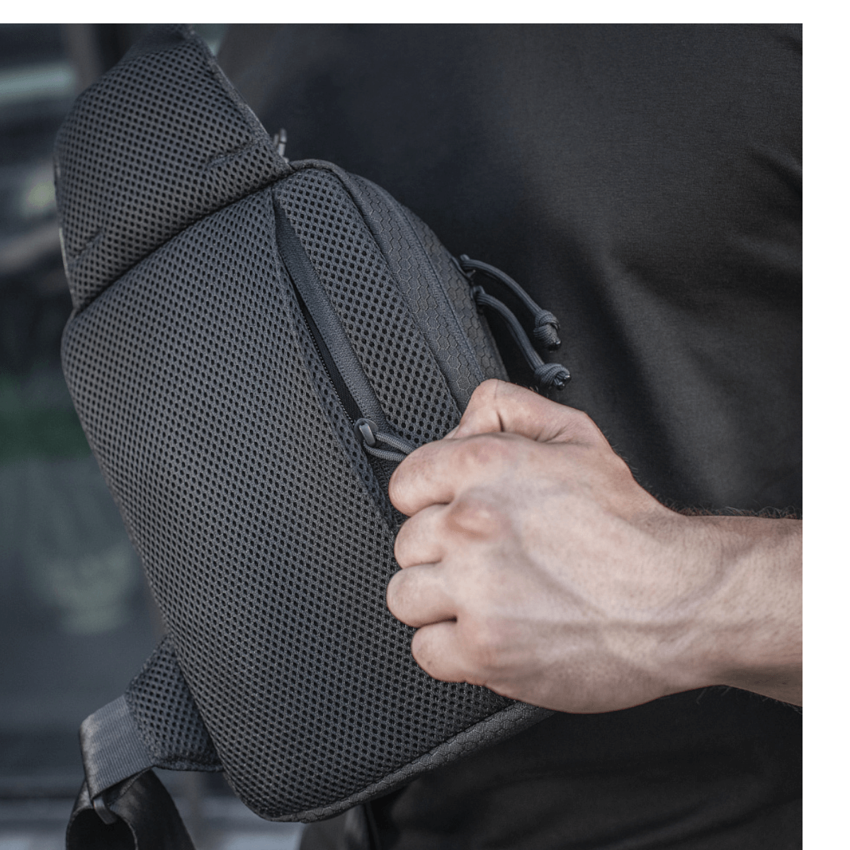 M-Tac Sling Pistoltaske Elite Hex käytössä säädettävällä olkahihnalla ja tilavilla osastoilla, valmistettu Cordura-materiaalista.