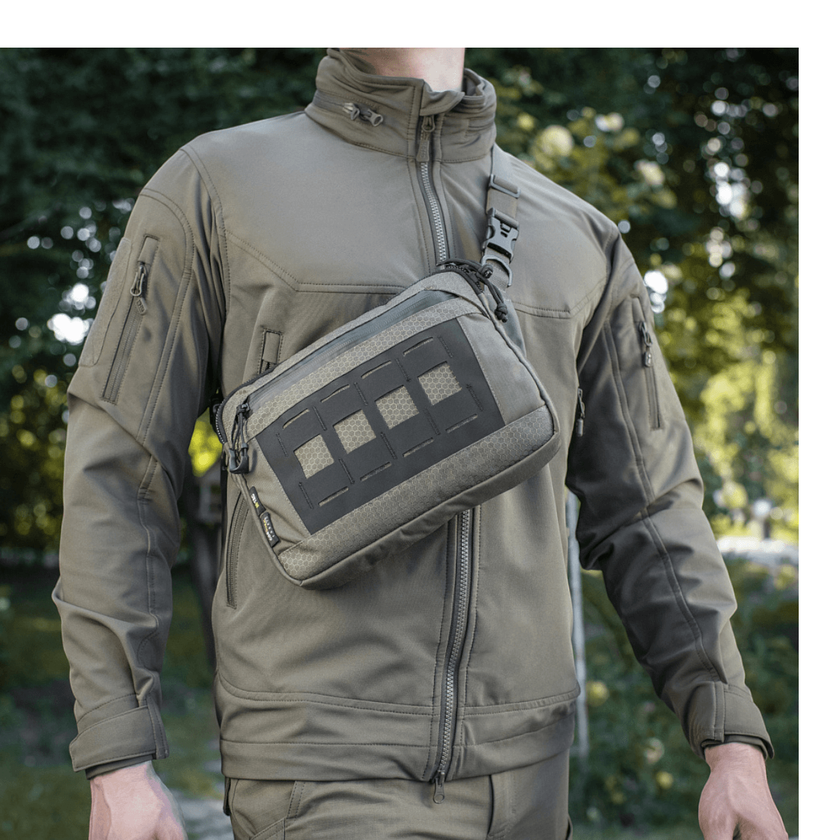 M-Tac Admin-laukku Eliteä kantaa henkilö metsässä, valmistettu kestävästä Cordura 500D:stä ja Hexistä, laadukkaat vetoketjut