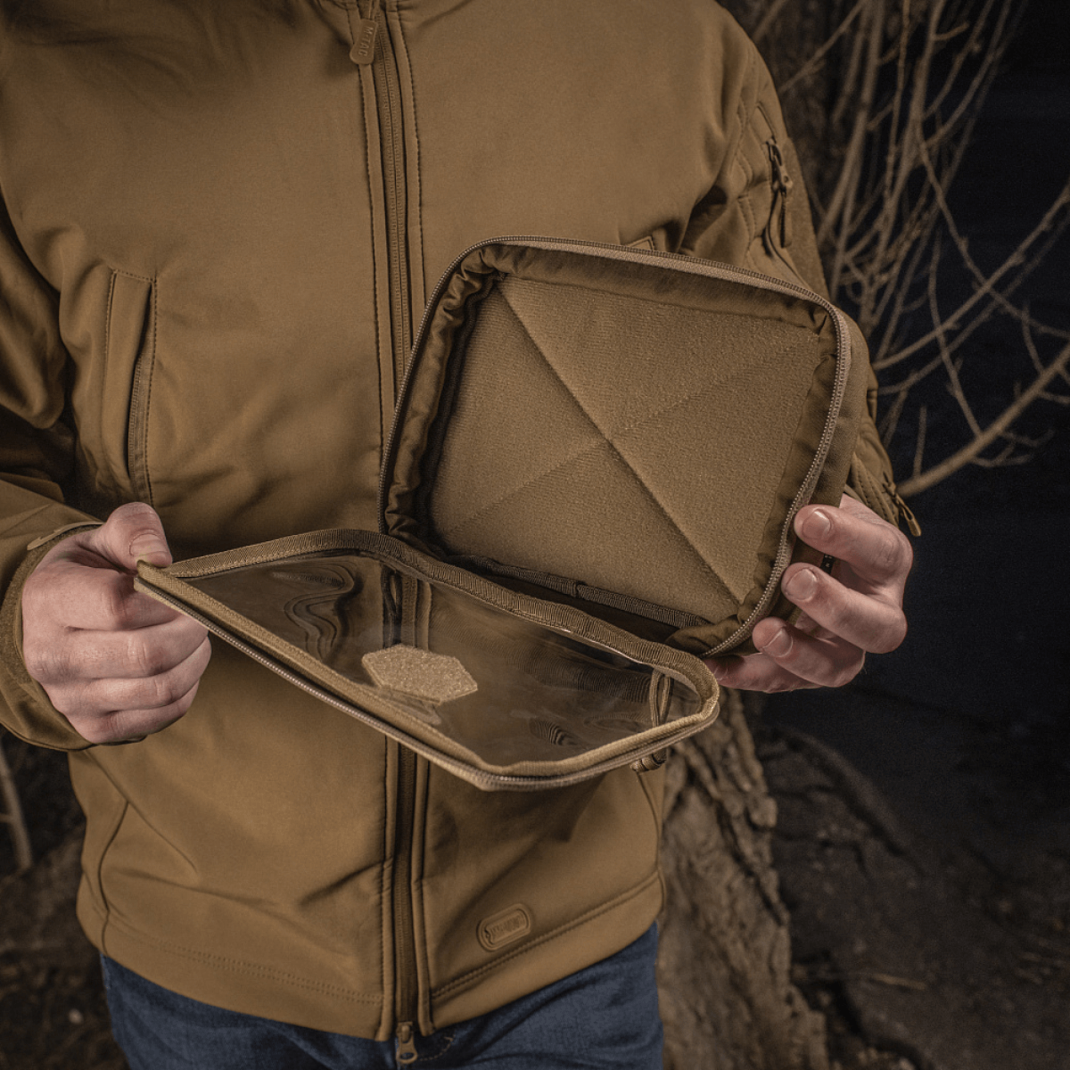 Henkilö pitelee M-Tac Utility Organizer Slim Elite Cordura 500D:stä läpinäkyvällä PVC-kalvolla ja sisäisellä Velcrolla EDC-kitille