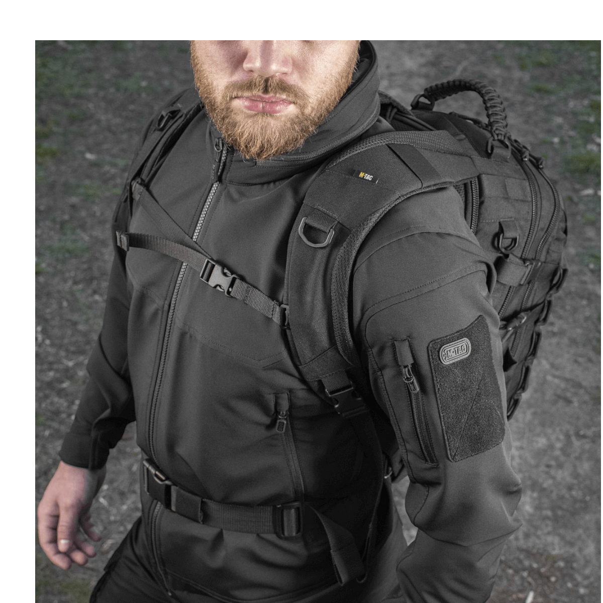 Mies kantaa M-Tac Mission Pack Elite -reppua ergonomisella muotoilulla, Cordura 1000D ja varustettuna MOLLE LASER CUT-systemillä.