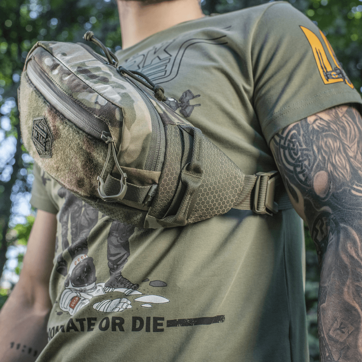M‑Tac Elite Hex -vyölaukku miehellä camo-kuosissa, sopiva taktiseen varustukseen ja päivittäiseen käyttöön, valmistettu Cordura-materiaalista.
