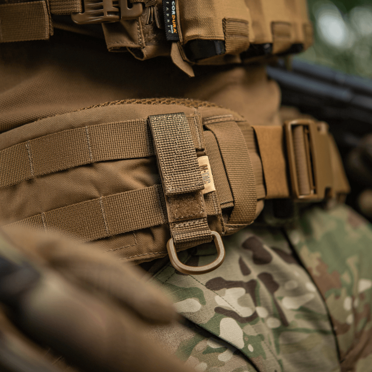 M-Tac D-ring-kiinnike MOLLE-järjestelmään taktiseen varustukseen, esittelee luotettavan ripustuksen ja säädettävän Velcro-lukituksen.