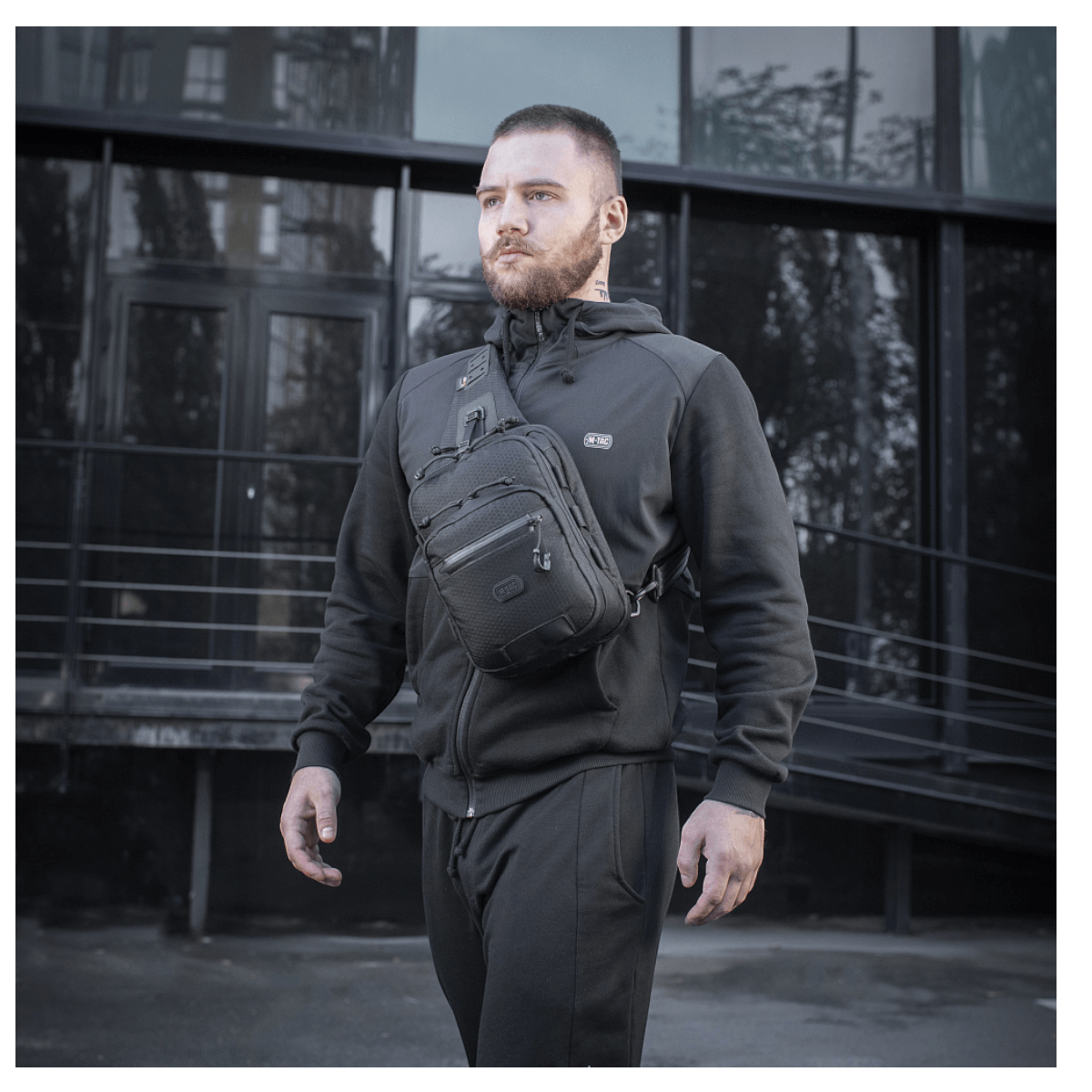 Mies kantaa M-Tac Cross Taske Slim Elite Hex -laukkua, tyylikäs ja toimiva laukku Cordura-materiaalista, varusteina YKK ja Woojin.