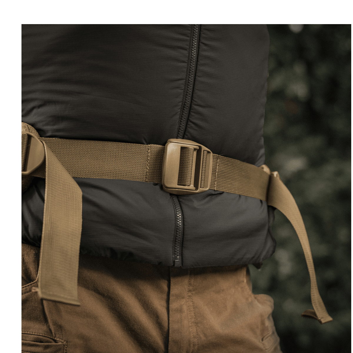 Henkilö kantaa M-Tac reppu Large Elite Hex Gen. IV säädettävällä vyöllä ja kestäviä materiaaleja käyttäen; painotus mukavuudessa.