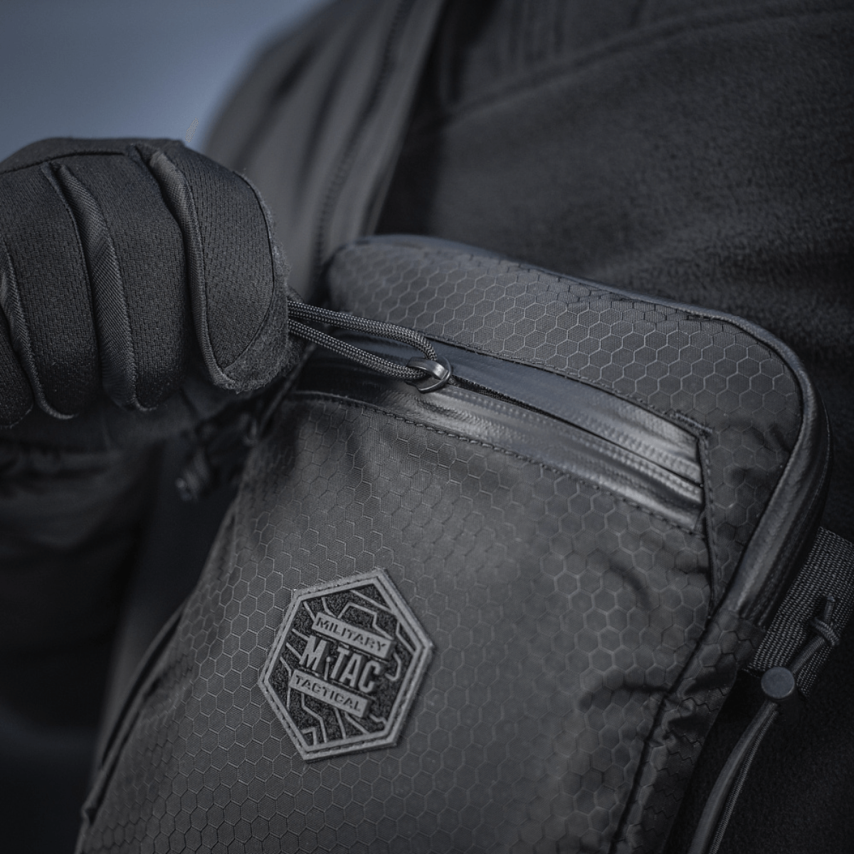 M‑Tac Pocket Bag Elite HEX käytössä, kompakti laukku kulutusta kestävästä materiaalista ja kestävä vetoketju, sopii EDC-varusteiden ja työkalujen säilytykseen.