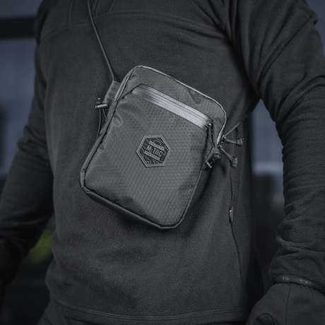 M-Tac Pocket Bag Elite HEX henkilöllä, kompakti laukku kulutusta kestävästä materiaalista YKK-vetoketjuilla, sopii EDC-varusteille.