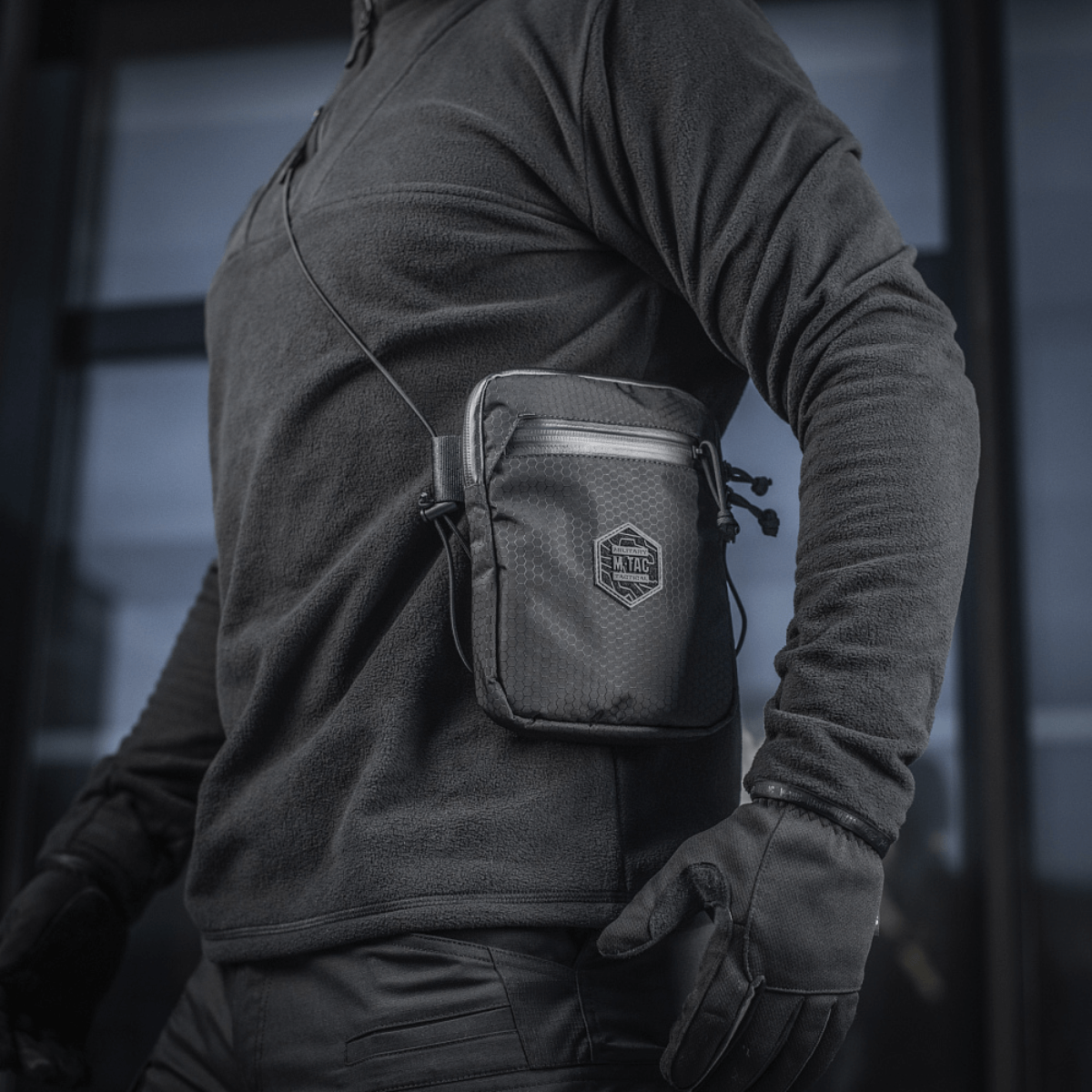 Henkilö M‑Tac Pocket Bag Elite HEX:n kanssa, kompakti laukku sopii EDC-varusteille ja avaimille, valmistettu kulutusta kestävästä materiaalista YKK-vetoketjuilla.