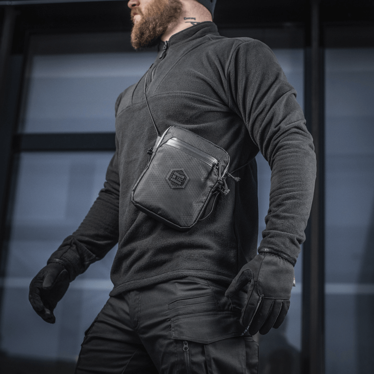 M-Tac Pocket Bag Elite HEX miehen kantamana, sopii kompaktiksi säilytykseksi EDC-varusteille, kulutusta kestävä materiaali ja YKK-vetoketjut.