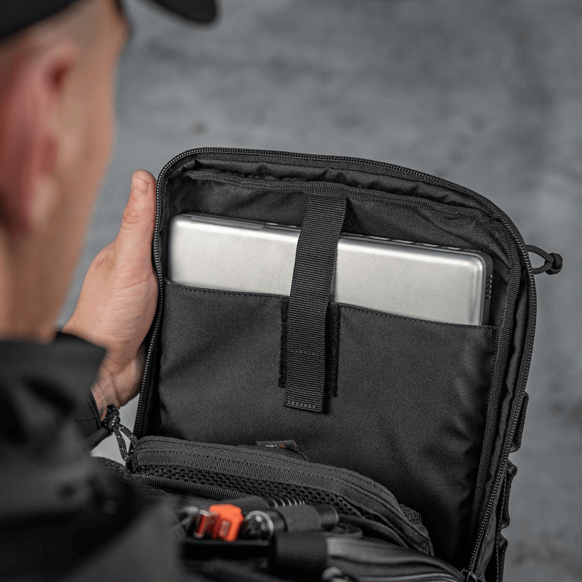 Henkilö avaa M-Tac Tablet Bag Laser Cut Hexin tabletti sisällä, näyttää lokeron nopeaan pääsyyn ja asiakirjoille.
