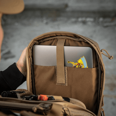 Henkilö katsoo M-Tac Tablet Bag Laser Cut Hexiin, tabletti sisätaskussa, sopii EDC:hen ja piilotettuun säilytykseen.