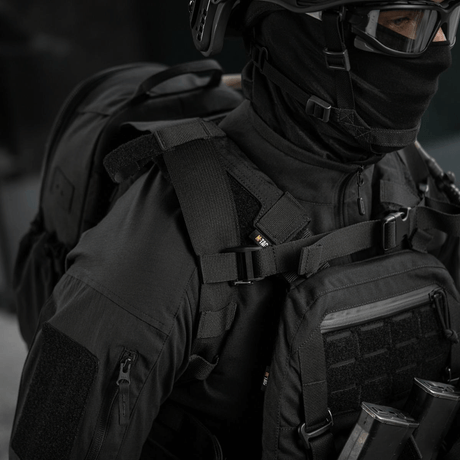M-Tac STURM Elite -reppu henkilöllä taktillisissa vaatteissa, MOLLE Laser Cut -paneeli ja kestävä muotoilu lyhytaikaisiin kenttäoloihin.
