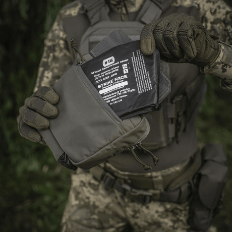 M-Tac Large Elite Gen.II olkalaukku taktisten varusteiden kanssa, valmistettu Cordura 500D:stä, käytössä päivittäiseen säilytykseen.