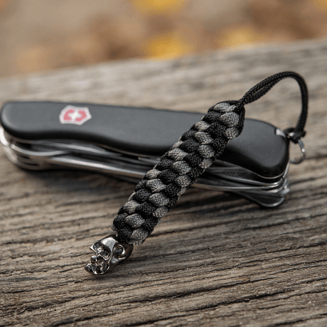M-Tac Knife Lanyard Helix Skull punottua paracordia, lisää tyyliä taskuveitsen kahvaan ja toimii joustavana jatkeena.