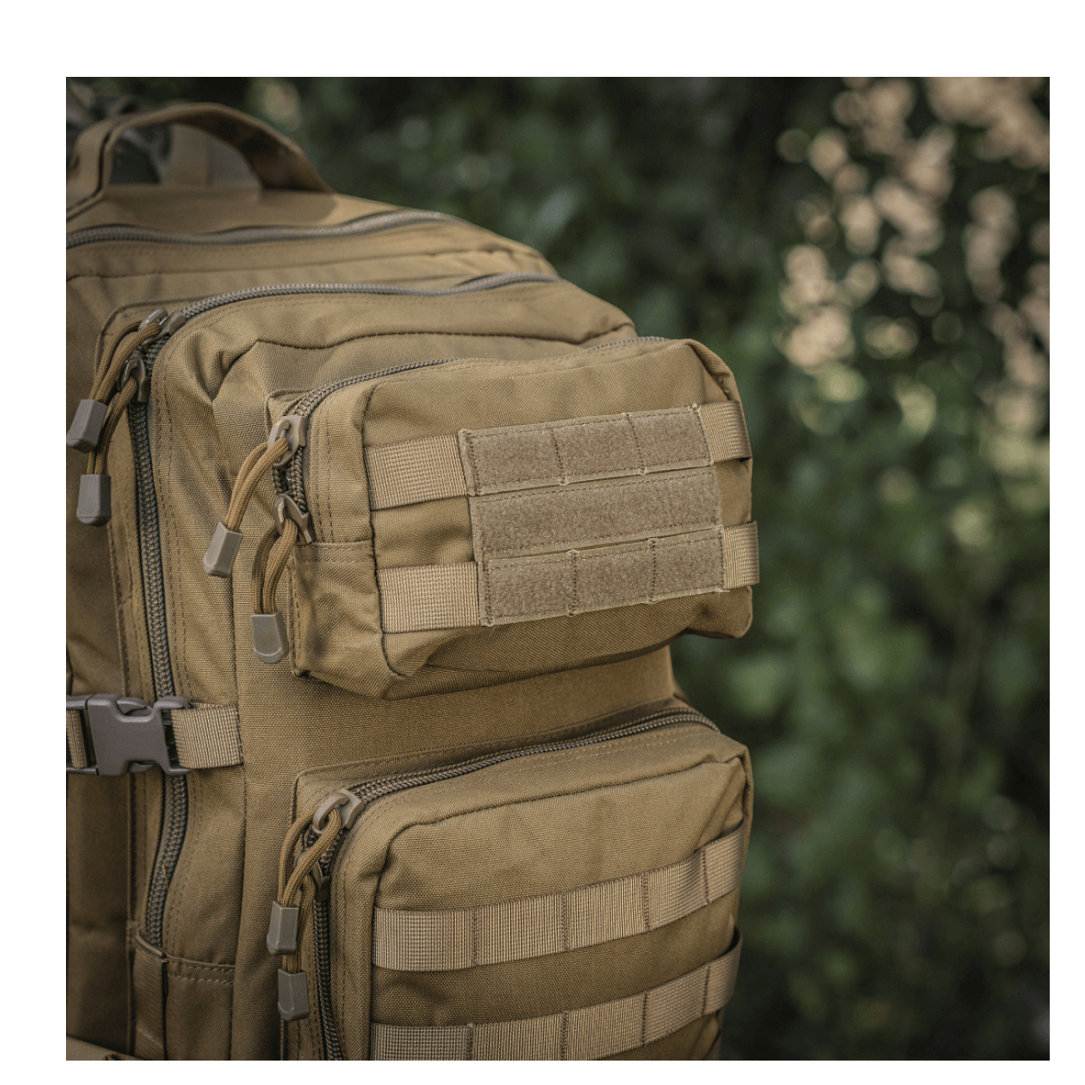 M-Tac Large Assault Pack -reppu taktiseen muotoiluun, MOLLE-järjestelmä ja lisätaskuja, kuvattu tiheässä metsässä.