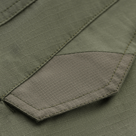 Yksityiskohta M-Tac Shorts Aggressor Gen.II Flexistä ripstop-materiaalilla ja Teflon-pinnoitteella, näyttää tiiviin ompeleen ja kestävän rakenteen.