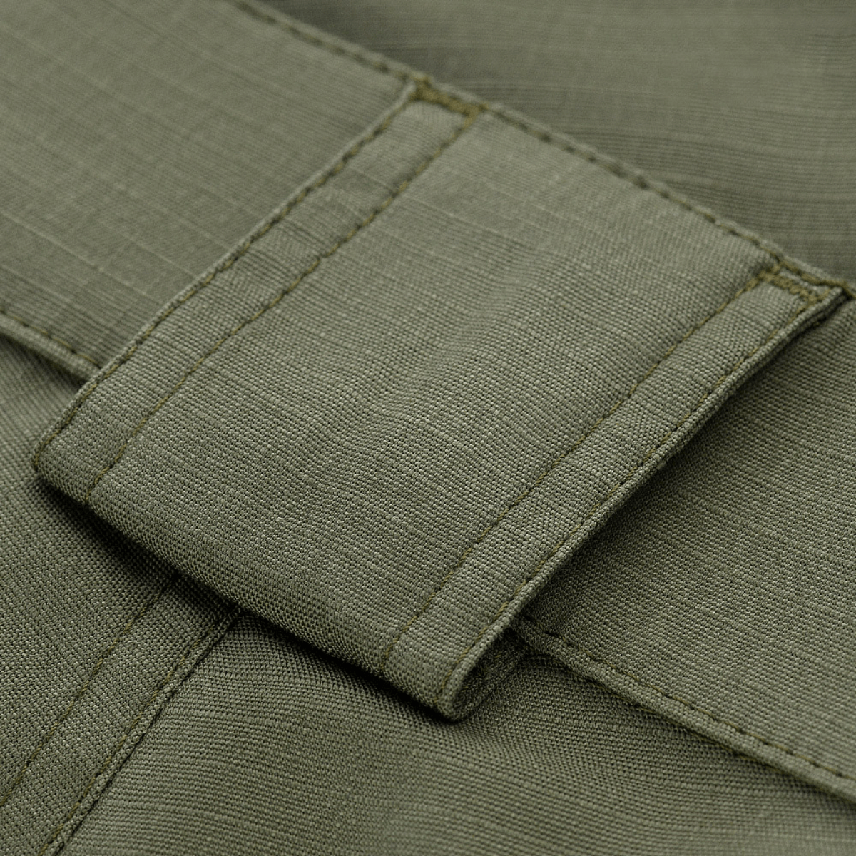 Yksityiskohta M-Tac Shorts Aggressor Gen.II Flexistä ripstop-materiaalilla ja Teflon-pinnoitteella, näyttää taktisen muotoilun.