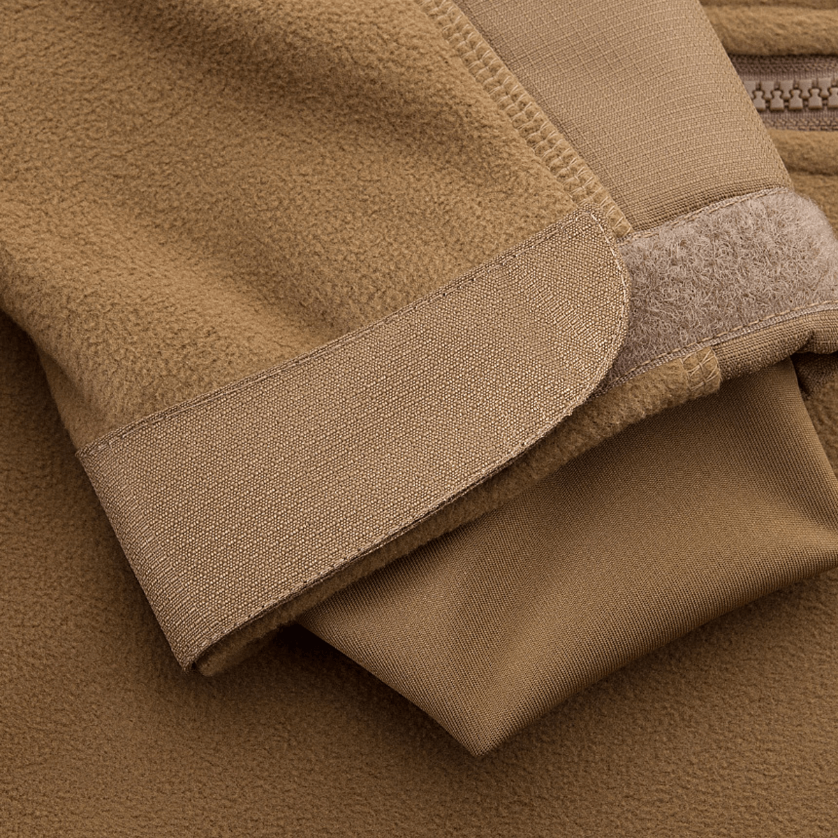 Lähikuva hihayksityiskohdasta M-Tac Norman Windblock Fleecejakke -takissa, beige WindBlock-materiaali ja Softshell-indlæg.