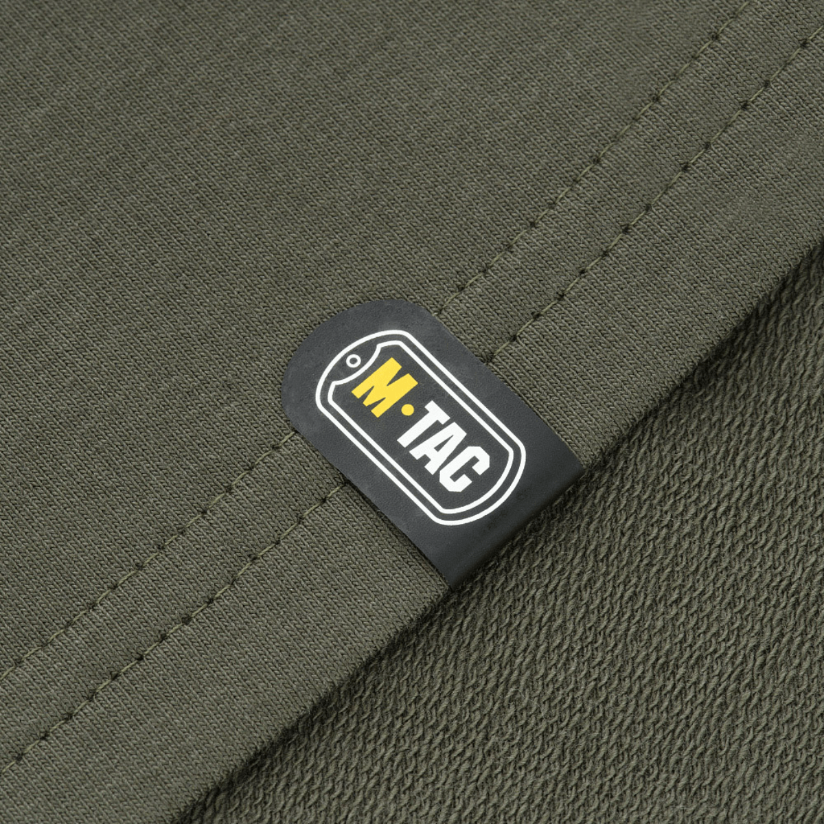M-Tac Pullover 4 Seasons, minimalistinen malli, stretch-kalvosimet, sopii ympäri vuoden, yksityiskohta M-Tac-logosta.