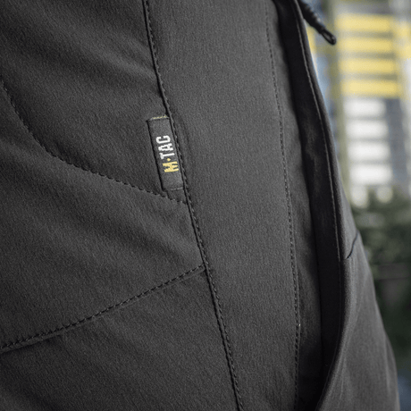 Lähikuva M-Tac Shorts Rubicon Flex -shortseista tumman oliivin värissä, näyttää cargotaskun suunnittelun maksimaaliseen liikkumisvapauteen.