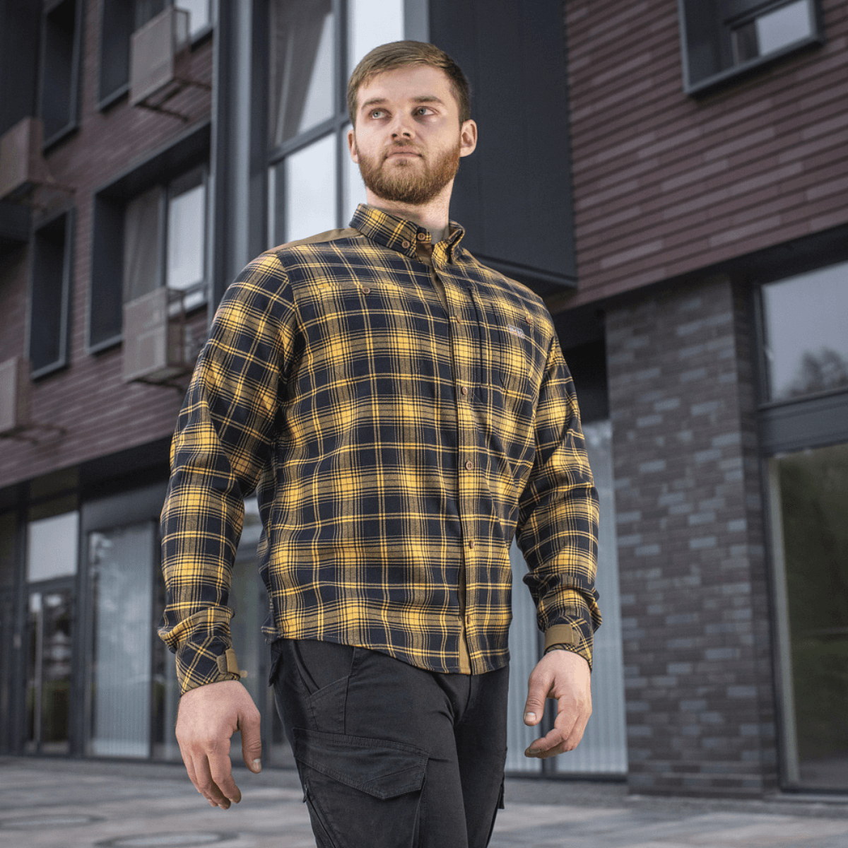 M-Tac Redneck -paita navy sininen/keltainen ruutukuosi, tyylikäs ja kestävä taktinen paita työhön ja vapaa-aikaan, nähty henkilöllä rakennusten edessä.