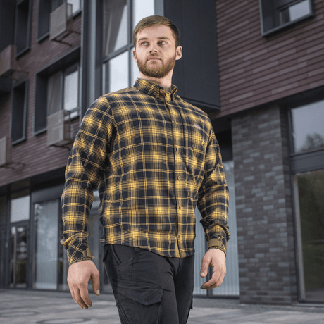 M-Tac Redneck -paita navy sininen/keltainen ruutukuosi, tyylikäs ja kestävä taktinen paita työhön ja vapaa-aikaan, nähty henkilöllä rakennusten edessä.