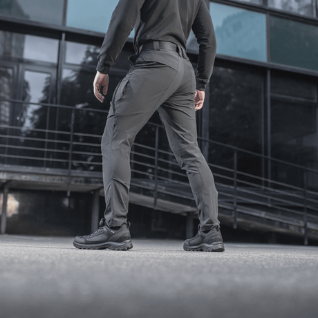 Henkilö pukeutuneena M-Tac Rubicon Flex -housuihin, sopivat harjoitteluun ja työhön, modernissa kaupunkiympäristössä. Mukava 4-Way Stretch -kangas.