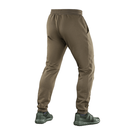 M-Tac Stealth Cotton -housut ruskeana, monikäyttöiset juoksu- ja kuntosalihousut, valmistettu 100% puuvillasta kuminauhalla vyötäröllä.