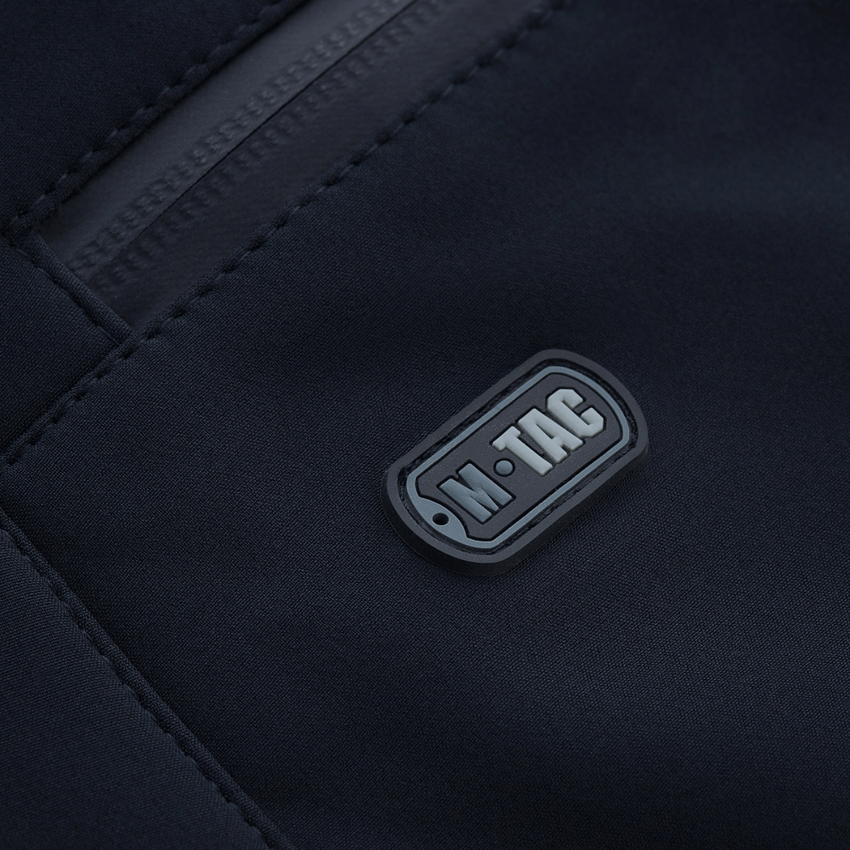 M-Tac Bukser Soft Shell Vinter materiaalin yksityiskohta merkkilogolla.