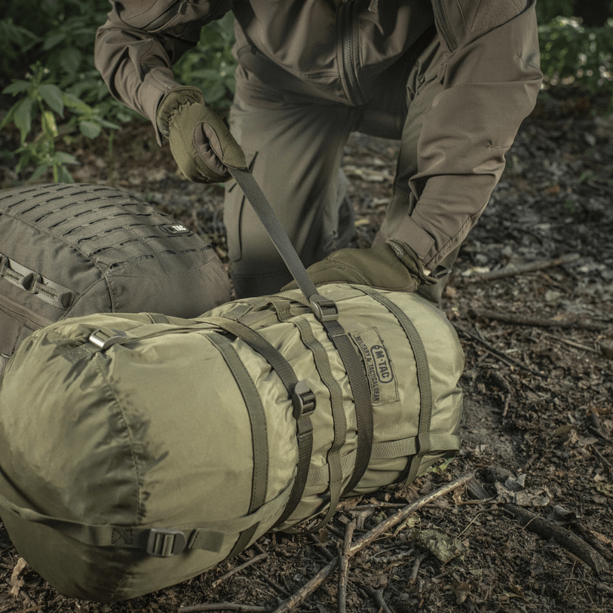 M-Tac puristusremmi kiinnitettynä reppuun retkellä turvalliseen lisävarusteiden säilytykseen, 100% nylon, leveys 25 mm.