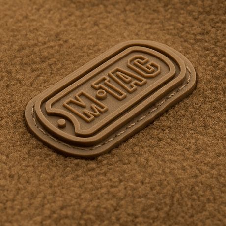 M-Tac Alpha Microfleece takki Gen.II -logo, korostaa edistynyttä muotoilua ja kulutuskestävyyttä kylmiin ulkoaktiviteetteihin.