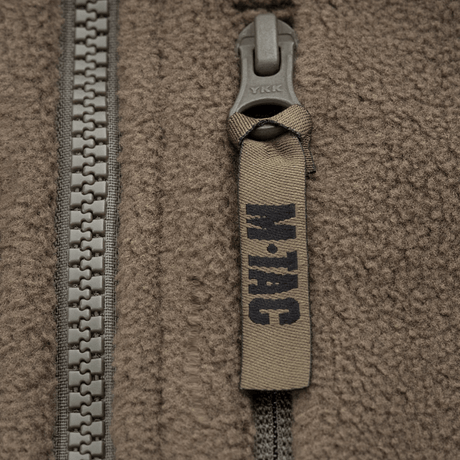 Lähikuva vetoketjusta M-Tac Alpha Microfleece takki Gen.II:stä, korostaa fleeceä ja kulutuskestävyyttä kylmässä säässä.