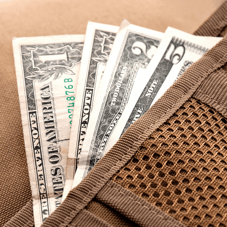 M-Tac Patch Panel Elite militaarityylissä, avattuna näkyvillä dollariseteleillä, näyttää CORDURA® -rakenteen ja Velcro-suljennan.