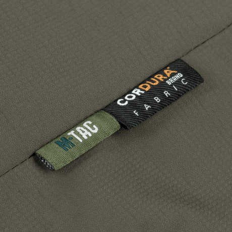 Lähikuva M-Tac Alpha Gen.III Pro talvitakista Cordura-kangaslabelilla, korostaa kestävyyttä ja laatua.