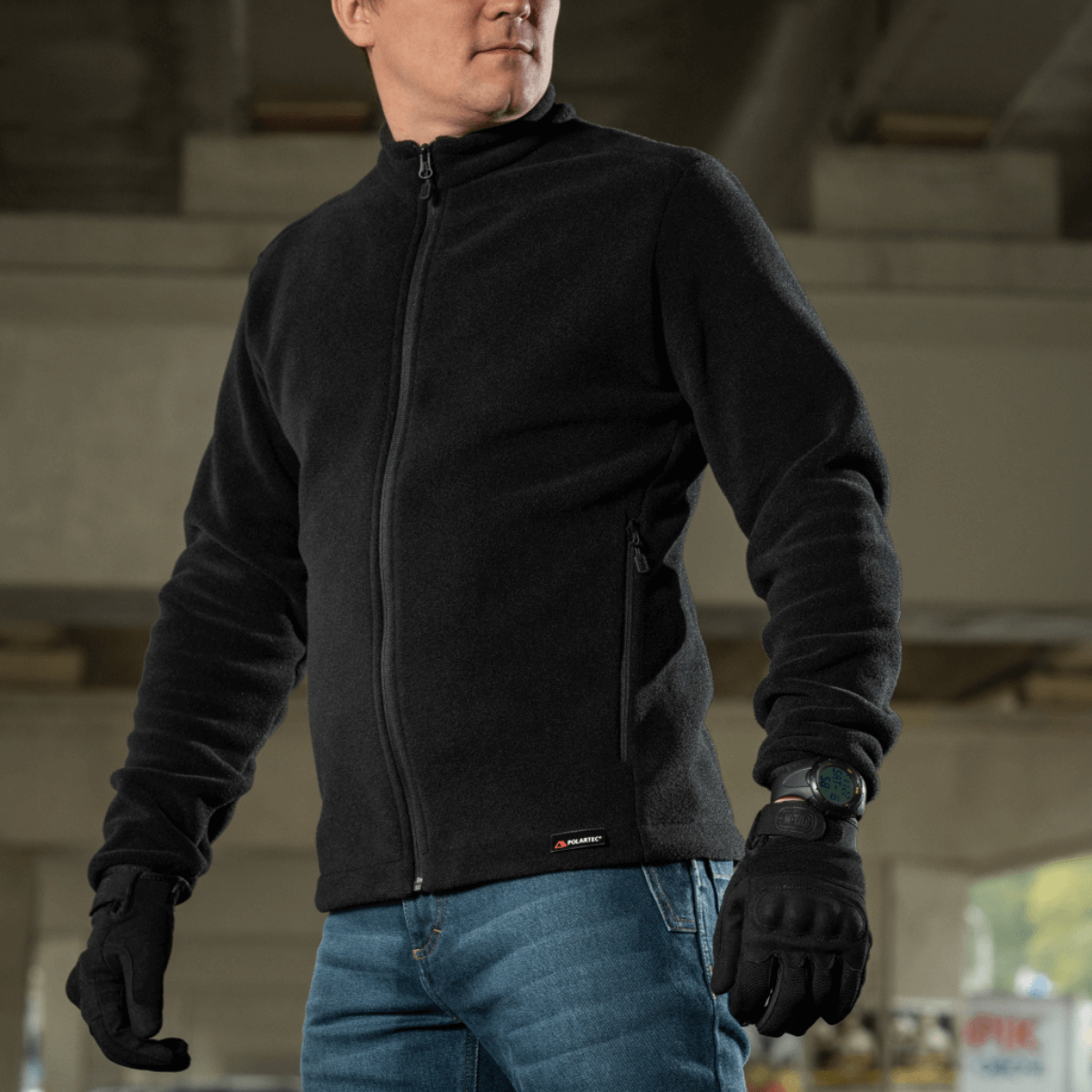 Mies käyttäen M-Tac Nord Polartec takkia, näyttää tyyliä ja toiminnallisuutta.